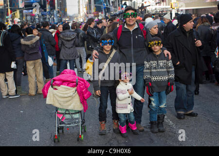 Une famille portant des lunettes 2012 a leur photo prise parmi la foule à New York Times Square le soir du Nouvel An 2011. Plus d'un million de personnes se joindront à la célébration d'accueillir 2012 à la Big Apple. Banque D'Images