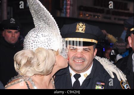 Lady Gaga, pose avec un agent de police à la nouvelle de l'an 2012 à Times Square dehors et environ pour la célébrité CANDIDS - SAT, , New York, NY Le 31 décembre 2011. Photo par : Ray Tamarra/Everett Collection Banque D'Images