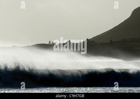 Une famille à la recherche à l'old Salt House à Port Eynon plage aujourd'hui qu'en mer les vagues déferlent sur la plage sur la péninsule de Gower, près de Swansea, le mardi 3 janvier 2012. Banque D'Images