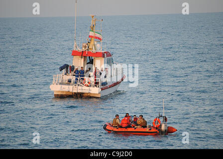 Les gardes-côtes américains affectés à la garde-côte Monomoy main sur les marins iraniens à la Garde côtière iranienne le 10 janvier 2012, dans le golfe Arabique. Plus tôt la faucheuse a sauvé six marins iraniens qui ont dû abandonner leur naufrage après dhow la salle des machines inondée. Banque D'Images