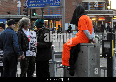 Londres, Royaume-Uni. 11Th Jan, 2012. Un manifestant portant une combinaison de saut à la prison d'orange et noir est assis sur le capot d'une boîte de jonction au cours de la Guantanamo Journée d'action. À 8h00 protestersTurnpike Lane, London, ont été marquant le 10e anniversaire de l'ouverture du camp de prisonniers. Banque D'Images