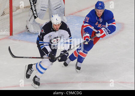 24 janvier 2012 - Newark, New Jersey, États-Unis - le défenseur des Jets de Winnipeg Zach Bogosian (4) tente d'effacer la zone wile poursuivi par les Rangers de New York center Derek Stepan (21) durant la première période d'action de la LNH entre les Jets de Winnipeg et les Rangers de New York au Madison Square Garden de New York, N.Y. Le Banque D'Images