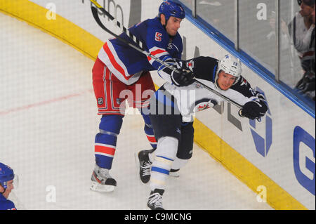 24 janvier 2012 - Newark, New Jersey, États-Unis - New York Rangers le défenseur Dan Girardi (5) contrôles Centre Winnipeg Jets Kyle Wellwood (13) pour la glace au cours de la troisième période d'action de la LNH entre les Jets de Winnipeg et les Rangers de New York au Madison Square Garden de New York, N.Y. Les Rangers défait les Jets Banque D'Images