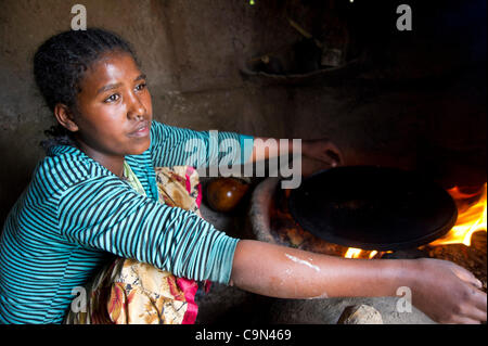 16 janvier 2012 - Farta (woreda, Gondar sud (zone, l'Éthiopie, le 16 janvier 2012, Ayva Niva), l'Éthiopie - travaillons au dessus d'une flamme dans une petite cuisine extérieure, un 16-year-old TESFA Projet pilote participant prépare l'injera, un pain local, à la substance dans d'Ayva Niva), l'Éthiopie. L'TESFA proje Banque D'Images