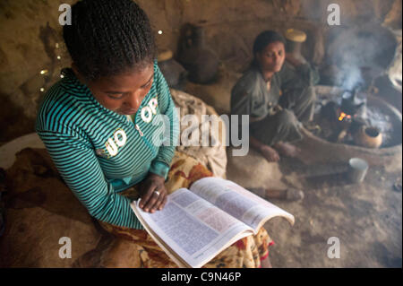 16 janvier 2012 - Farta (woreda, Gondar sud (zone, l'Éthiopie, le 16 janvier 2012, Ayva Niva), l'Ethiopie - comme sa belle-sœur prépare du café sur un feu ouvert, un 16-year-old TESFA participant du projet pilote d'éducation civique des études après son retour à la maison de l'école à l'Ayva Niva), l'Éthiopie. Circb est fournissant monito Banque D'Images
