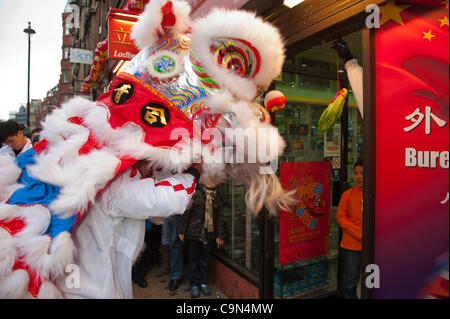 29 janvier 2012. Londres, Royaume-Uni - Un lion dancer la coutume traditionnelle de Cai Ching, littéralement plumer les verts, dans un magasin situé dans le quartier chinois -Le 10e anniversaire de célébrations du Nouvel An chinois à Trafalgar Square, sont les plus grandes célébrations à l'extérieur de la Chine. Photo:Graham Lawrence/Alamy News. Banque D'Images