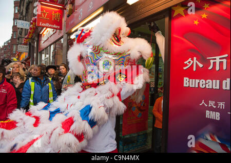 29 janvier 2012. Londres, Royaume-Uni - Un lion dancer la coutume traditionnelle de Cai Ching, littéralement plumer les verts, dans un magasin situé dans le quartier chinois -Le 10e anniversaire de célébrations du Nouvel An chinois à Trafalgar Square, sont les plus grandes célébrations à l'extérieur de la Chine. Photo:Graham Lawrence/Alamy News. Banque D'Images