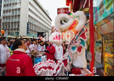 29 janvier 2012. Londres, Royaume-Uni - Un lion dancer la coutume traditionnelle de Cai Ching, littéralement plumer les verts, dans un magasin situé dans le quartier chinois -Le 10e anniversaire de célébrations du Nouvel An chinois à Trafalgar Square, sont les plus grandes célébrations à l'extérieur de la Chine. Photo:Graham Lawrence/Alamy News. Banque D'Images