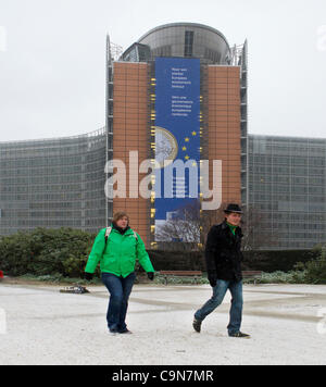 Les gens au travail à pied dans la neige au-delà de la Commission européenne du Berlaymont à Bruxelles le matin de la grève générale appelée par les syndicats en Belgique. Banque D'Images