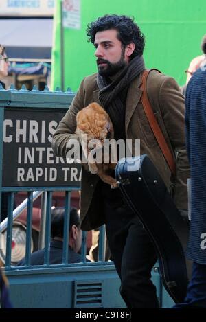 17 février 2012 - Manhattan, New York, États-Unis - l'Acteur OSCAR ISAAC dans le rôle de personnage principal Llewyn Davis porte un chat et guitare hors de la ville de ''1'' de la station de métro de train à Christopher Street dans le West village lors du tournage d'une scène du nouveau film du frère Coen ''Inside Llewyn Davis''. ''Insi Banque D'Images