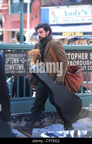 17 février 2012 - Manhattan, New York, États-Unis - l'Acteur OSCAR ISAAC dans le rôle de personnage principal Llewyn Davis porte un chat et guitare hors de la ville de ''1'' de la station de métro de train à Christopher Street dans le West village lors du tournage d'une scène du nouveau film du frère Coen ''Inside Llewyn Davis''. ''Insi Banque D'Images