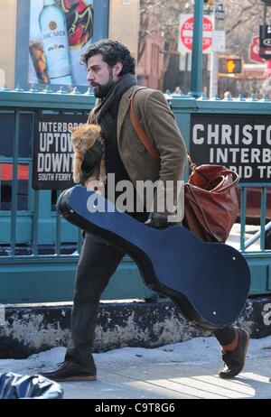 17 février 2012 - Manhattan, New York, États-Unis - l'Acteur OSCAR ISAAC dans le rôle de personnage principal Llewyn Davis porte un chat et guitare hors de la ville de ''1'' de la station de métro de train à Christopher Street dans le West village lors du tournage d'une scène du nouveau film du frère Coen ''Inside Llewyn Davis''. ''Insi Banque D'Images