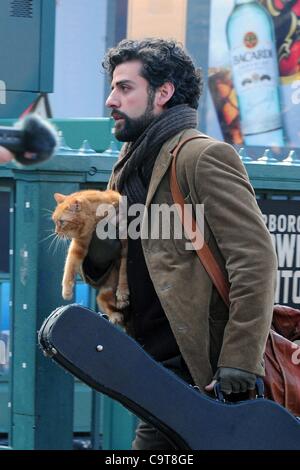 17 février 2012 - Manhattan, New York, États-Unis - l'Acteur OSCAR ISAAC dans le rôle de personnage principal Llewyn Davis porte un chat et guitare hors de la ville de ''1'' de la station de métro de train à Christopher Street dans le West village lors du tournage d'une scène du nouveau film du frère Coen ''Inside Llewyn Davis''. ''Insi Banque D'Images