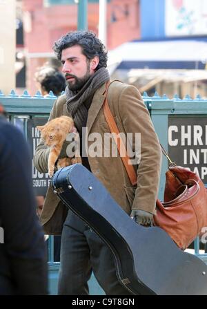 17 février 2012 - Manhattan, New York, États-Unis - l'Acteur OSCAR ISAAC dans le rôle de personnage principal Llewyn Davis porte un chat et guitare hors de la ville de ''1'' de la station de métro de train à Christopher Street dans le West village lors du tournage d'une scène du nouveau film du frère Coen ''Inside Llewyn Davis''. ''Insi Banque D'Images