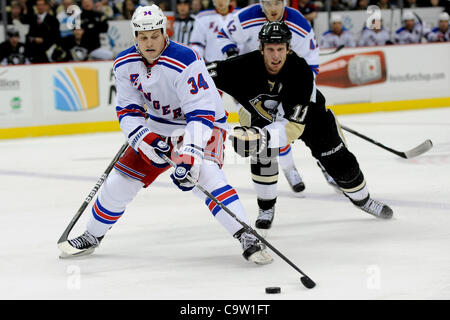 Le 21 février 2012 - Pittsburgh, Pennsylvanie, États-Unis - New York Rangers center John Mitchell (34) patins d'avance sur Jordan Staal centre des Penguins de Pittsburgh (11) avec la rondelle au cours de la troisième période que les Penguins de Pittsburgh prendre sur les Rangers de New York au CONSOL Energy Center à Pittsburgh, PA...les Pingouins Banque D'Images