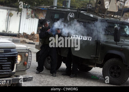 25 février 2012 - Hébron, en Cisjordanie, territoire palestinien - Des policiers israéliens fire des gaz lacrymogènes lors d'une démonstration par des Palestiniens et des militants de la paix demandent la réouverture de l'une des principales rues de la ville de Cisjordanie d'Hébron, le 24 février 2012. Des centaines de Palestiniens ont manifesté pour exiger la c Banque D'Images