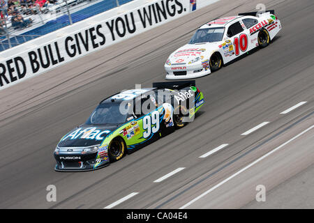 11 mars 2012 - Las Vegas, Nevada, États-Unis - Carl Edwards, conducteur de la # 99 Aflac Ford Fusion, passe le tour de voiture David Reutimann, conducteur de la # 10 Chevrolet Impala Construction d'Accell, au cours de la passionnante course à la NASCAR Sprint Cup Series Kobalt Tools 400 à Las Vegas Motor Speedway j Banque D'Images