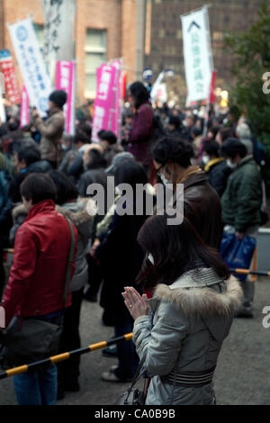 Le 11 mars 2012, Tokyo, Japon - une femme prie des victimes du grand séisme de l'Est du Japon et du tsunami au parc Hibiya. De nombreuses personnes se sont réunies pour prier et célébrer le premier anniversaire du grand séisme de l'Est du Japon et aussi pour manifester contre l'énergie nucléaire. (Photo de Rodrigo Reyes Marin/ Banque D'Images