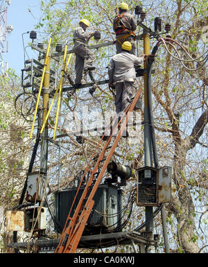 Karachi Electric Supply Company (KESC) les travailleurs occupés à travailler à un transformateur d'électricité sans mesures de sécurité qui peut dangereux pour eux a besoin de l'attention du ministère concerné au cour de la ville le mercredi 14 mars, 2012. Banque D'Images