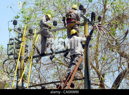 Karachi Electric Supply Company (KESC) les travailleurs occupés à travailler à un transformateur d'électricité sans mesures de sécurité qui peut dangereux pour eux a besoin de l'attention du ministère concerné au cour de la ville le mercredi 14 mars, 2012. Banque D'Images