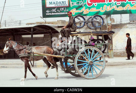 Un cheval-cavalier panier porte-carts pousser à gagner sa vie pour subvenir aux besoins de sa famille, traverse une route à Quetta le jeudi 15 mars, 2012. Banque D'Images