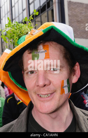 Belfast, Royaume-Uni. 17 mars, 2012. Homme avec drapeau tricolore irlandais, chapeau vert et regardant le shamrock St Patrick Day Parade à Belfast Banque D'Images