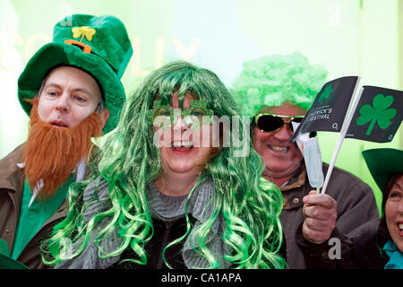 Fans agitant des drapeaux et portant une perruque verte sur le parcours du défilé du Défilé de la Saint-Patrick, Londres Banque D'Images