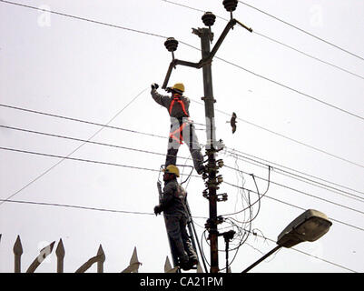 Electric Supply Company (KESC) les travailleurs occupés à travailler à un poteau d'électricité au jardin à Karachi le Jeudi, Mars 22, 2012. Banque D'Images