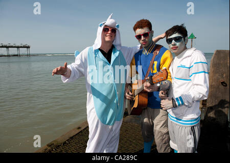 Les étudiants de l'université à jouer de la musique au soleil, profiter de la météo du printemps chaud et ensoleillé au bord de la mer, Aberystwyth au Pays de Galles au Royaume-Uni. 24 mars 2012 Banque D'Images