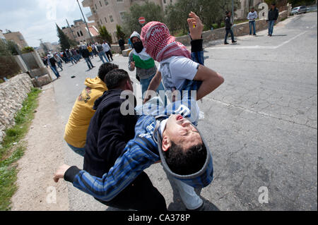 Bethléem, TERRITOIRES PALESTINIENS OCCUPÉS - le 30 mars : un Palestinien à surmonter par les gaz lacrymogènes est effectuée à l'égard de la sécurité au cours d'affrontements au checkpoint de Bethléem au cours de la Journée de la Terre de protestation. Banque D'Images