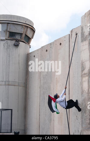 Bethléem, TERRITOIRES PALESTINIENS OCCUPÉS - le 30 mars : Une balance palestiniens le mur de séparation israélien au cours d'affrontements au checkpoint de Bethléem au cours de la Journée de la Terre de protestation. Banque D'Images