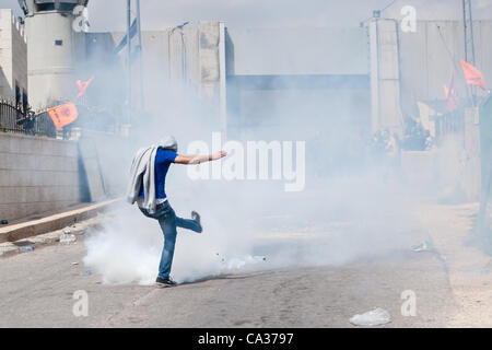 Bethléem, TERRITOIRES PALESTINIENS OCCUPÉS - le 30 mars : un Palestinien lance une grenade lacrymogène tirée par des soldats israéliens lors d'affrontements au checkpoint de Bethléem au cours de la Journée de la Terre de protestation. Banque D'Images