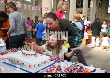 Londres, Royaume-Uni, 02/06/2012. Les gens en chêne de l'Evangile se sont réunis à l'église All Hallows, Savernake Road à tenir une fête de rue du Jubilé. Une mère et sa fille à admirer le gâteau qui célèbre la vie de la Reine sur son jubilé de diamant. Banque D'Images