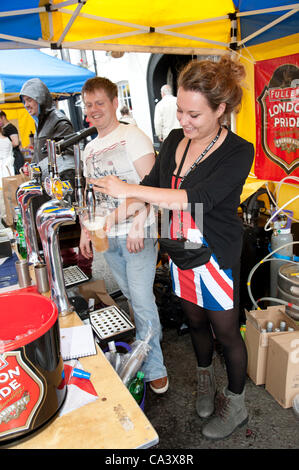 Winchester Diamond Jubilee street party Hampshire UK 03juin 2012 Young attractive barmaid portant une robe de style Union Jack servant sur le pints Broadway à Winchester Banque D'Images