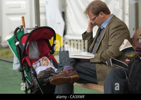 Dimanche 3 juin 2012. Hay-on-Wye, Powys, Wales, UK. Visiteurs inconscients de la pluie se détendre et lire à l'extérieur de la librairie Pembertons au 25e Festival du foin. Crédit photo : Graham M. Lawrence/Alamy Live News. Banque D'Images