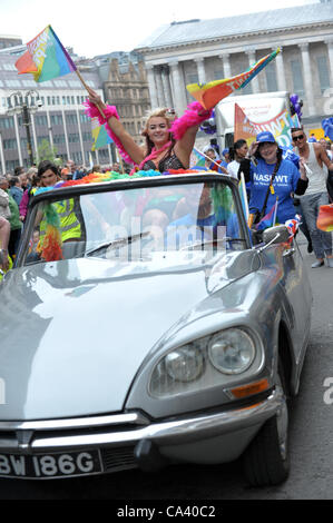 Femme blonde en agitant des drapeaux arc-en-ciel porter un soutien-gorge assis sur le dos d'un gris convertible Citroen DS à Birmingham Pride Parade Banque D'Images