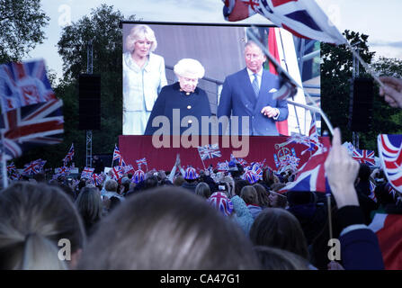 Londres, Royaume-Uni. Le 4 juin 2012. Fans dans le parc de St James, Londres. Regardez sur les grands écrans comme La Reine, arriver à la Diamond Jubilee concert , avec le prix du Pays de Galles et la duchesse de Cornouailles. Banque D'Images