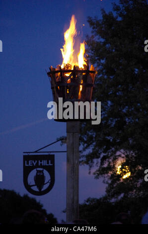 04/06/12. Ley Hill, près de Chesham, Buckinghamshire, Royaume-Uni. La lune qui brille à travers les arbres aux couleurs vives derrière la balise. L'éclairage des phares à travers le Royaume-Uni célèbre le jubilé de diamant de la Reine. Des centaines de personnes se sont réunies pour regarder, et connaît également un feu d'artifice après sur Ley Hill commun. Banque D'Images