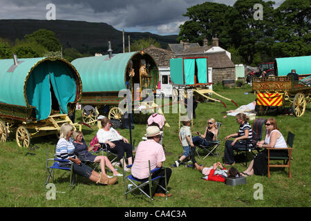 Caravanes de voyageurs tziganes ; feu de camp familial avec des caravanes tziganes traditionnelles de la Caravan de Vardo ou des chariots couverts de toile « Bow Top » en route vers le rassemblement annuel à Appleby, South Lakeland , UK CoB and Romany showman hébergement Wagon of the Traveling Community, camping à Bainbridge, dans les Dales du Yorkshire du Nord,En route vers la foire hippique Appleby, Royaume-Uni Banque D'Images