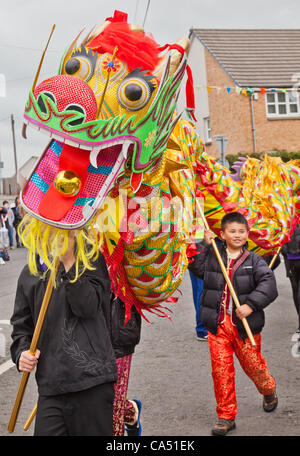 Dragon chinois soutenu par les enfants dans le cadre de la célébration du relais de la flamme olympique en passant par le village de Barrmill dans North Ayrshire, Ecosse, le 8 juillet, 2012. Banque D'Images