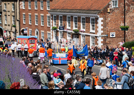 Samedi 9 juin 2012. Knaresborough, Yorkshire, UK. Le Grand Lit de Knaresborough procession de course passe le long de High Street. Knaresborough La course est un événement annuel organisé par les Lions de Knaresborough. La procession thème cette année olympique est des Nations Unies. Tous les profits iront à des Lions Fonds de charité. Banque D'Images