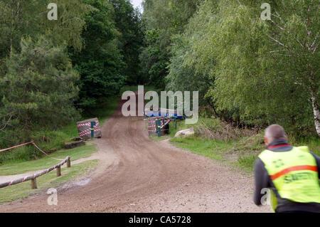 Le maréchal de sécurité jusqu'à la Peugeot 309 conduite par Nigel Hunt avec Andy Wright en tant que co-pilote qui s'est écrasé après avoir heurté une ornière sur la piste en forêt avant le tour 18 sur le Sherwood Pines stade. Banque D'Images