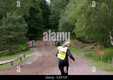 Le maréchal de sécurité jusqu'à la Peugeot 309 conduite par Nigel Hunt avec Andy Wright en tant que co-pilote qui s'est écrasé après avoir heurté une ornière sur la piste en forêt avant le tour 18 sur le Sherwood Pines stade. Banque D'Images