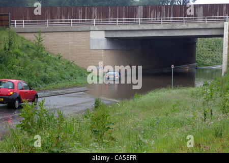 Lundi 11 juin 2012, Hindhead, Surrey, UK. La pluie tombée pendant la nuit lourde causant des inondations à la Hammer Lane, passage souterrain sous l'A3, à 1,6 km au sud du tunnel de Hindhead. Une BMW tente de traverser en roulant sur la chaussée. Banque D'Images