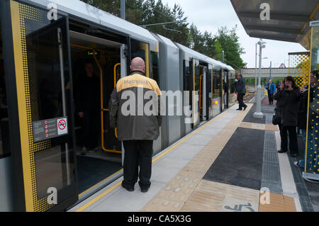 13 juin 2012. Un employé de Metrolink à l'arrêt de tramway d'oreillons Oldham attendent le tram pour commencer son voyage de retour à Manchester après avoir terminé le premier transport de passagers sur la nouvelle ligne de tramway Metrolink à Oldham. Banque D'Images