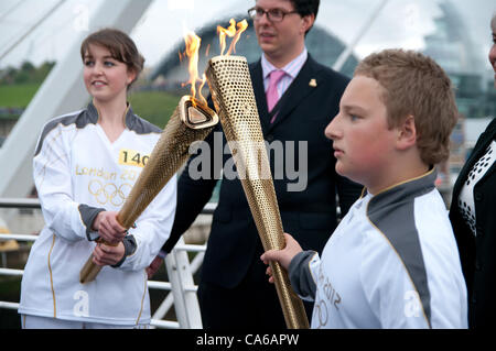 Newcastle sur Tyne, Royaume-Uni, 15 juin 2012 La flamme est transmise entre porteurs pour le dernier tronçon du voyage sur Newcastle Quayside. William Hardy, droite, était le dernier relayeur à Newcastle. C'était la fin de la journée 28 de la torche pour le voyage de Londres en 2012. © Colin Edwards / Alamy Live News Banque D'Images