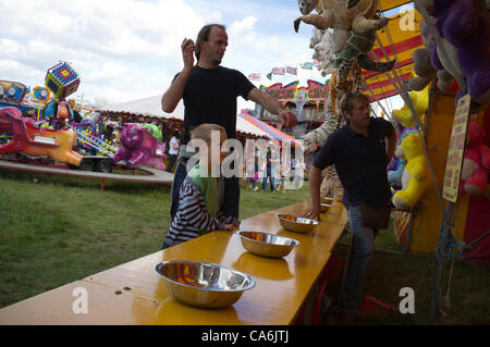 17 juin 2012, Wimbledon London,UK. Famille traditionnelle fête foraine. L'homme tente de frapper une série de boîtes pour gagner un prix Banque D'Images