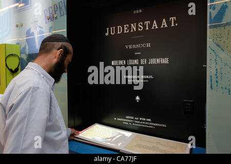 Un juif religieux lit une copie de Der Judenstaat, une brochure écrite par Theodor Herzl et publiée en 1896 dans laquelle il envisageait la fondation d'un futur État juif indépendant au cours du XXe siècle, au Centre d'éducation du Cimetière civil national de Mount Herzl West Jérusalem Israël Banque D'Images