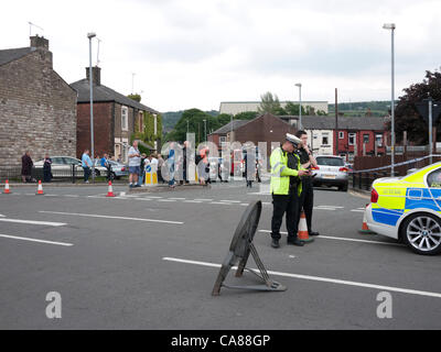 Oldham, grand Manchester, UK. 26 juin 2012. La police de la circulation et de remplir les rues de Crompton façon, une route à proximité de ce matin explosion d'une maison dans la région de Shaw d'Oldham. Un enfant est mort et un homme est pris au piège sous les décombres après un certain nombre de maisons ont été endommagées dans un cas présumé d'explosion de gaz dans la région de Oldham, la police a dit. Banque D'Images