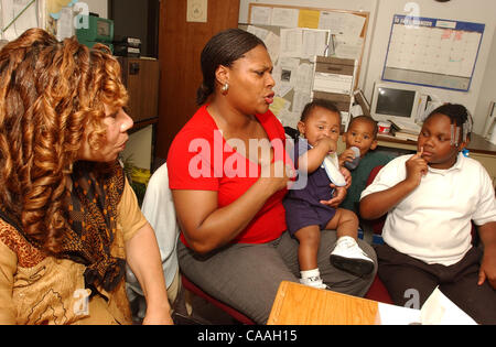 Jun 05, 2003 - Cincinnati, Ohio, USA - PATRICIA LOVEJOY (L) directeur de la foi de l'église de Morningstar basée programme de soutien pour les personnes en difficulté un parle avec 'client' TRACEY capable, 32 ans, et ses trois enfants KHARA capable, 8, (R) DARREN JOHNS,3, et DETRAY JONES, 3mois,sur ses genoux. (Ima Crédit Banque D'Images